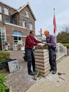 jan smolenaars is met een andere vrijwilliger het hek aan het maken